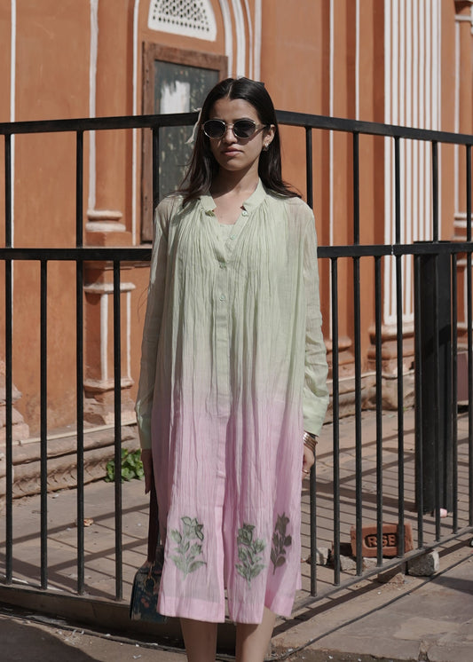 Woman standing on a balcony with a decorative building facade in the background
